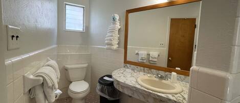 Un baño con inodoro, lavabo y espejo.