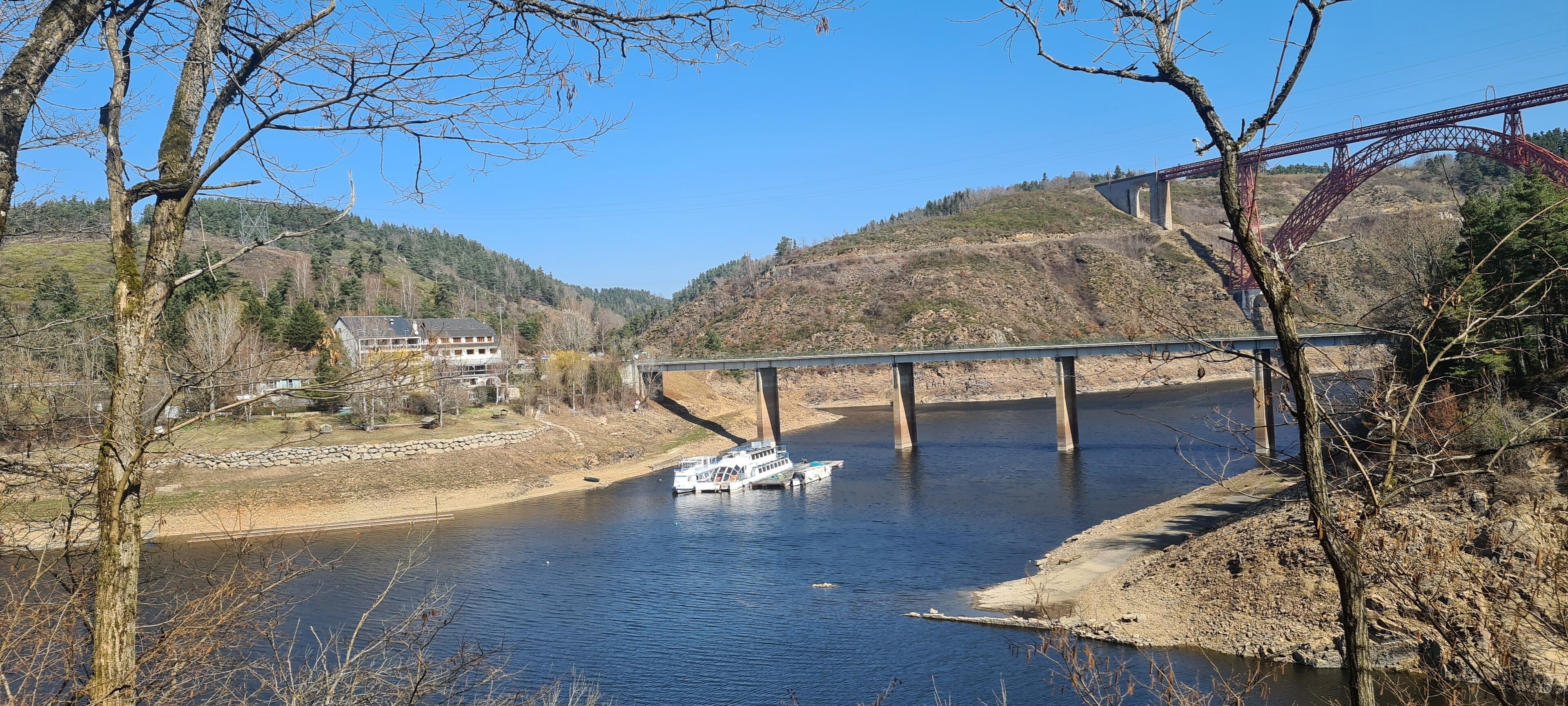 A river with a bridge and a boat.