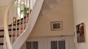 A spiral staircase with white railings and wooden steps leading to an upper floor. - Vacation apartment "Fritz" in the Villa Hünlich with a rondel view of Upper Lusatia (Wilthen)