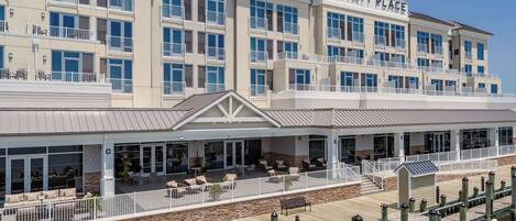 A multi-story hotel with outdoor seating areas and a dock extending into the water.