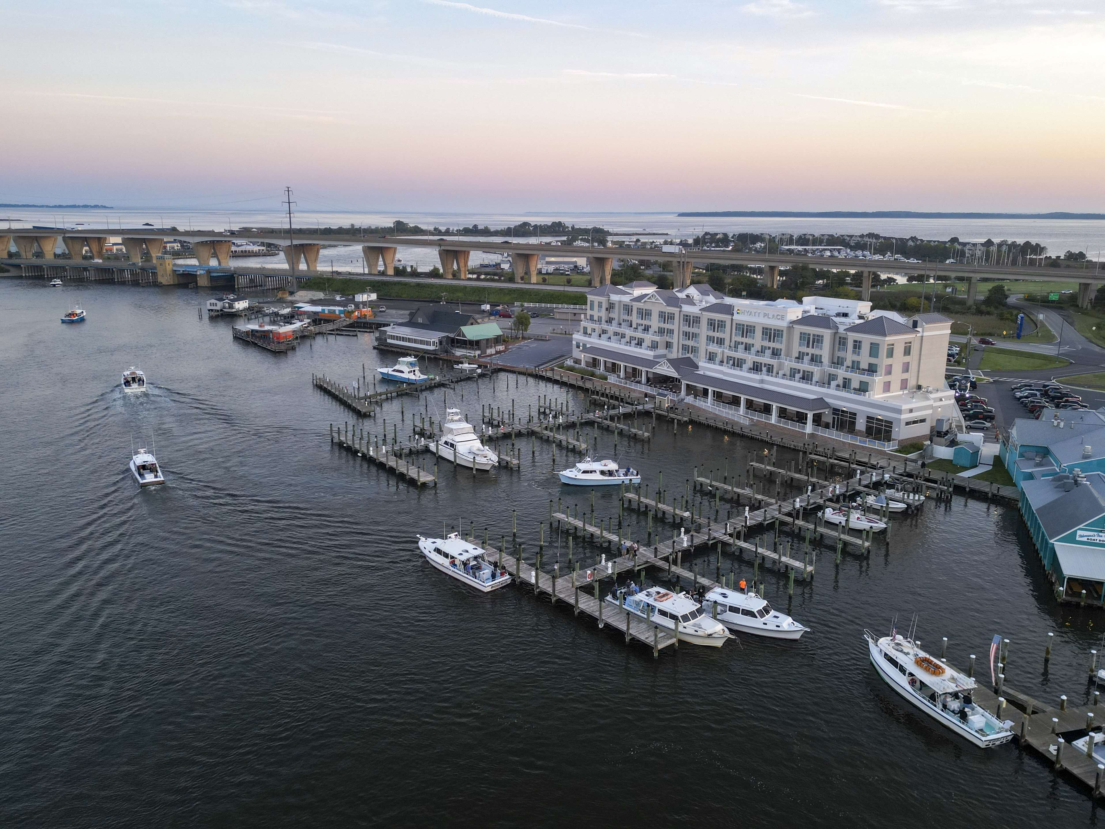 A marina with multiple docks, a large hotel, and boats.