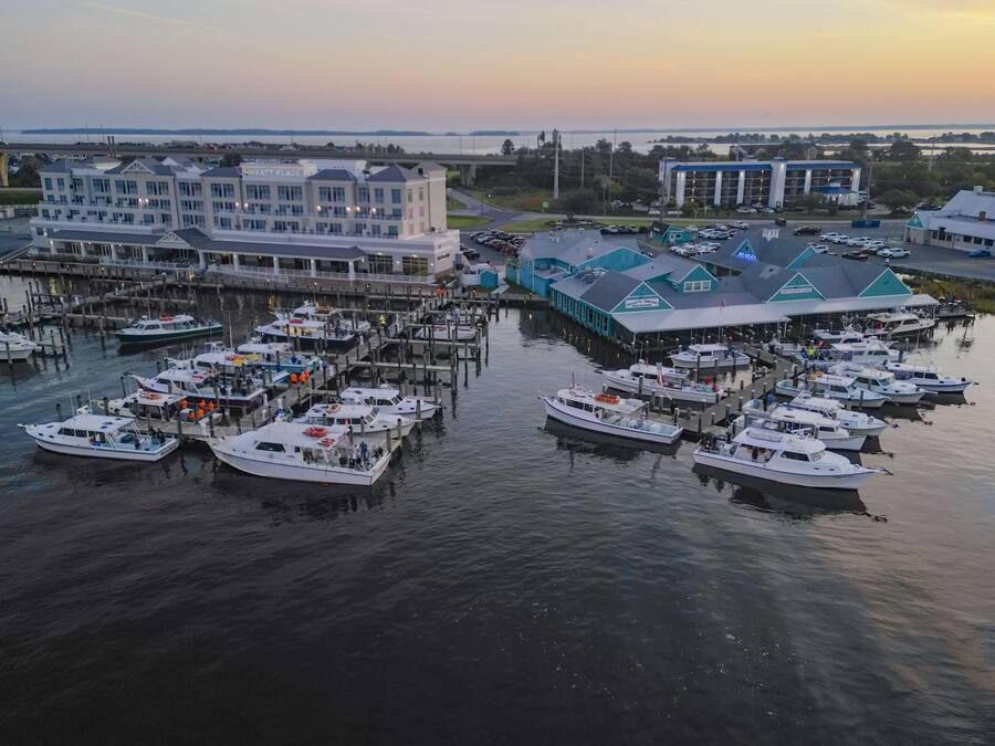 A marina with multiple boats docked, a large building labeled "Hyatt Place," and a restaurant with a blue roof.