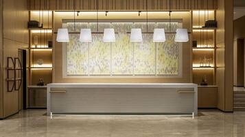 A modern reception area with a marble counter, pendant lighting, and a patterned wall.