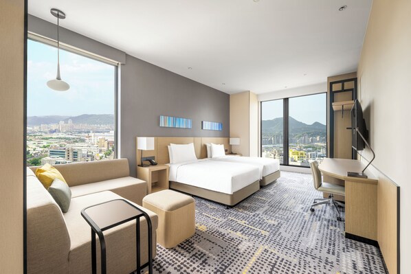 A hotel room with a large bed, a sofa, a desk, and a view of the city. - Hyatt Place New Taipei City Xinzhuang (New Taipei City)