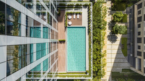 A rooftop pool with a glass barrier, surrounded by greenery and adjacent to a modern building. - Hyatt Place New Taipei City Xinzhuang (New Taipei City)