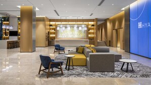 A modern hotel lobby with seating areas, a reception desk, and a blue wall with the hotel name. - Hyatt Place New Taipei City Xinzhuang (New Taipei City)