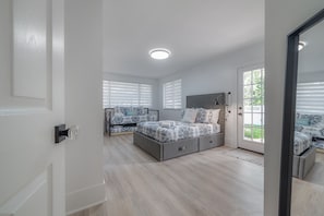 Relax in a serene bedroom with a large bed, grey headboard, and storage unit.
