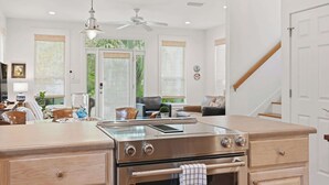 A modern kitchen with a central island, stainless steel appliances, and a view of the outdoors. - Anchor House- Heated Pool- 4 Bikes!- Prime Beach A (Santa Rosa Beach)