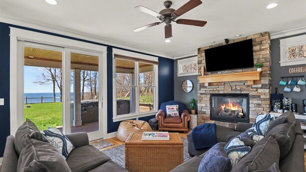 Una sala de estar con chimenea, televisor y vistas al exterior.