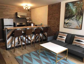 Cozy living space with a kitchenette, sofa, and dining area.