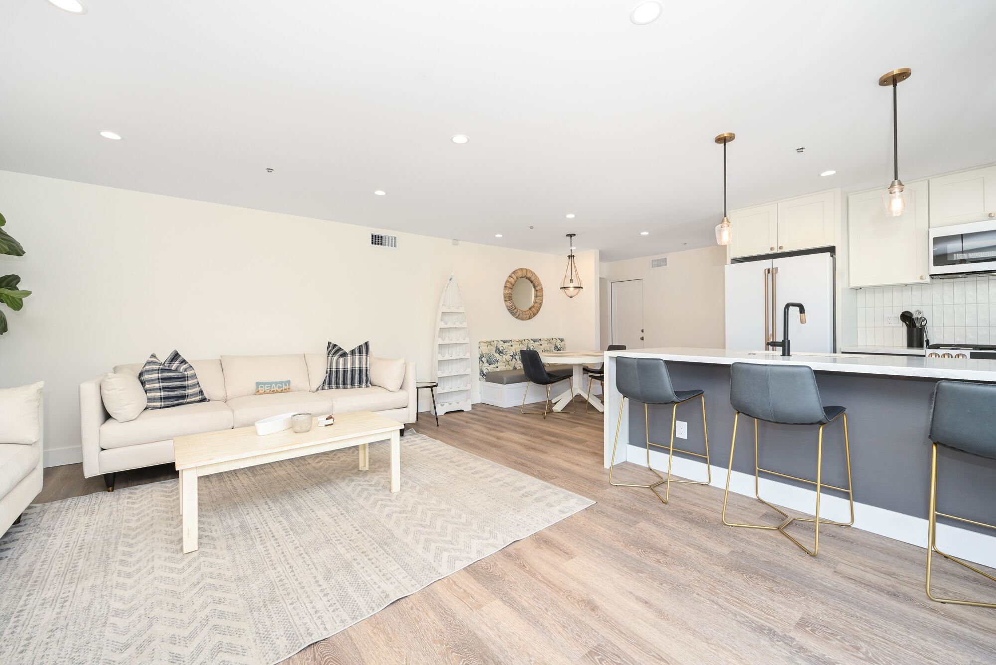 A modern living room with a sofa, coffee table, and a small dining area.
