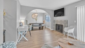 Ein modernes Wohnzimmer mit Essbereich, Kamin und einer großen Uhr an der Wand.