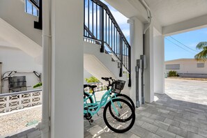A turquoise bicycle parked under a white porch with a staircase leading to an upper level. - Catch n' Relax Anglers Ultimate Waterfront Retreat, 50’ Dock, Pool Home Modern (Marathon)