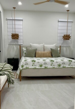 A bedroom with a bed, two hanging lamps, a nightstand, and a window with blinds. - Catch n' Relax Anglers Ultimate Waterfront Retreat with 50’ Dock Modern New Home (Marathon)