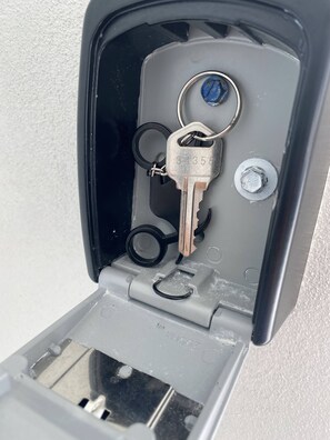 Una caja para guardar llaves con una llave metálica y un candado.
