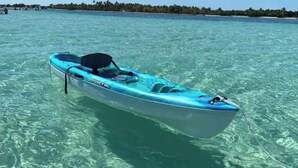 A small, single-person kayak named 'ODYSSEY 100' floating in clear turquoise water. - Catch n' Relax Anglers Ultimate Waterfront Retreat with 50’ Dock Modern New Home (Marathon)