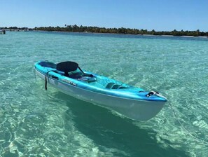 A small, single-person kayak named 'ODYSSEY 100' floating in clear turquoise water. - Catch n' Relax Anglers Ultimate Waterfront Retreat with 50’ Dock Modern New Home (Marathon)