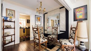 A dining area with a wooden table and chairs, a chandelier, and a large mirror. - Mayfair Centre 3-Bed 6-Guest Art Nouveau Flat in 1729 Private House (London)