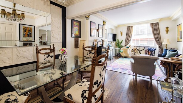 A spacious living room with a glass dining table, elegant chairs, and a comfortable sofa. - Mayfair Centre 3-Bed 6-Guest Art Nouveau Flat in 1729 Private House (London)
