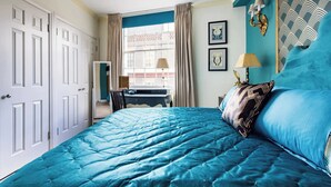 A bedroom with a large bed, a desk, and a window with curtains. - Mayfair Centre 3-Bed 6-Guest Art Nouveau Flat in 1729 Private House (London)