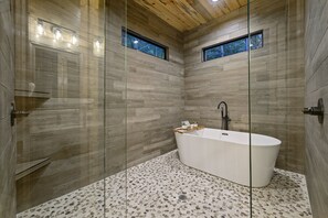 Bathtub, hair dryer, towels, toilet paper