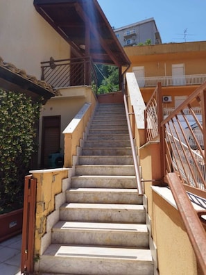 Uma escadaria que leva a um edifício com varanda.