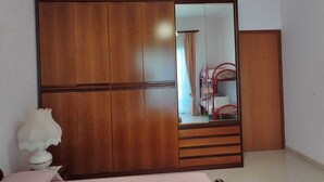 Ein Schlafzimmer mit einem Holzschrank, einem Spiegel und einem Bett.