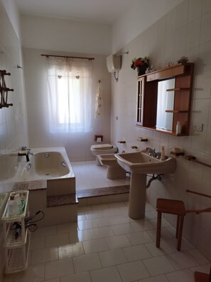 A bathroom with a bathtub, two sinks, a toilet, and a shower. - LOCAZIONE TUR. GAMBINO MARIANA NICOLETTA (Agrigento)