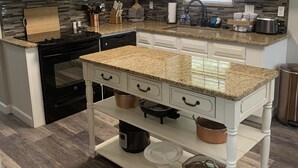 Eine moderne Küche mit weißen Schränken, Granit Arbeitsplatten und Edelstahlgeräten.