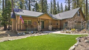 Eine Lodge mit Steinfundament, einer grünen Tür und einer Veranda.