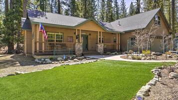 A lodge with a stone foundation, a green door, and a covered porch.
