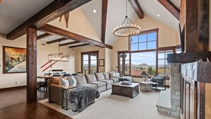 A spacious living room with a large sectional sofa, a fireplace, and a stone wall.