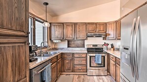 Une cuisine avec des meubles en bois, des appareils électroménagers en acier inoxydable et une fenêtre.