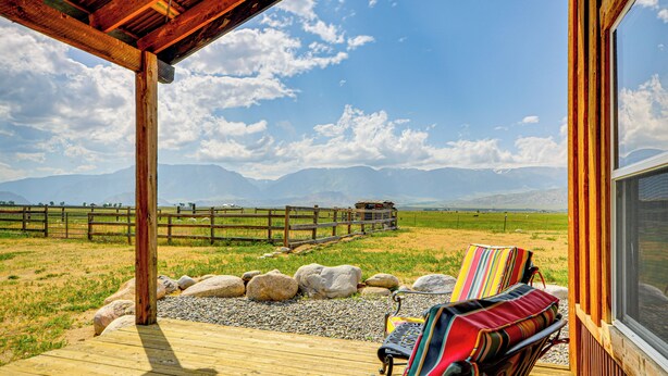 A wooden deck with a bench and a view of a mountainous landscape.