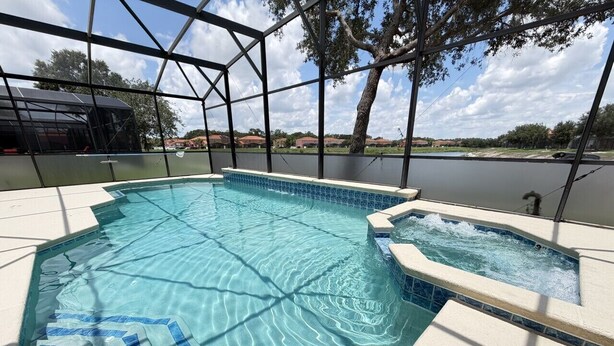 Una piscina con agua cristalina, un jacuzzi y vistas del paisaje circundante.