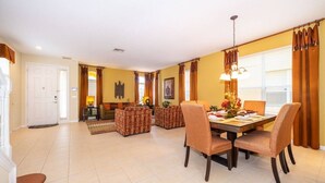Un salón amplio con una mesa de comedor, sillas y un sofá.
