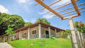 Ein Haus mit Ziegeldach, überdachter Veranda und einem Rasen.