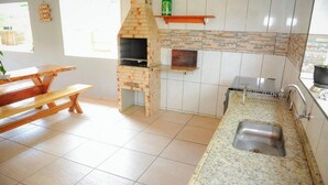 Eine Küche mit Backofen aus Ziegeln, einem Holztisch und einer Arbeitsplatte aus Granit.