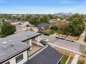 A residential area with houses, a street, and a city skyline in the background.