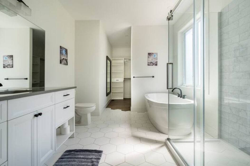 Une salle de bain moderne avec une douche à parois de verre, une baignoire sur pieds et un lavabo blanc.