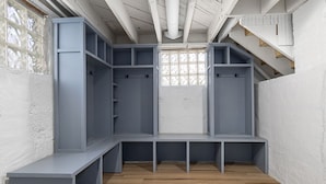 Ein Zimmer mit eingebauter Sitzbank und Stauraumelementen, einem Fenster mit Ausblick und einer Treppe.