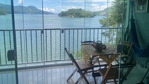 A balcony with a view of a lake and distant islands. - Desfrute dessa maravilha. (Angra dos Reis)