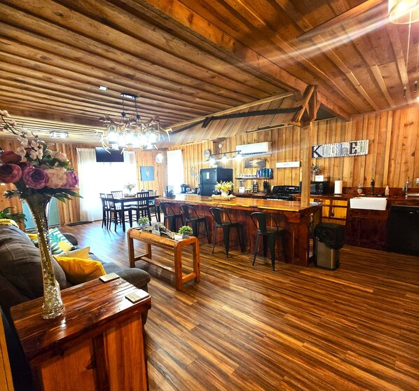 Un intérieur rustique avec des planchers en bois, un coin repas, une cuisine et un bar.