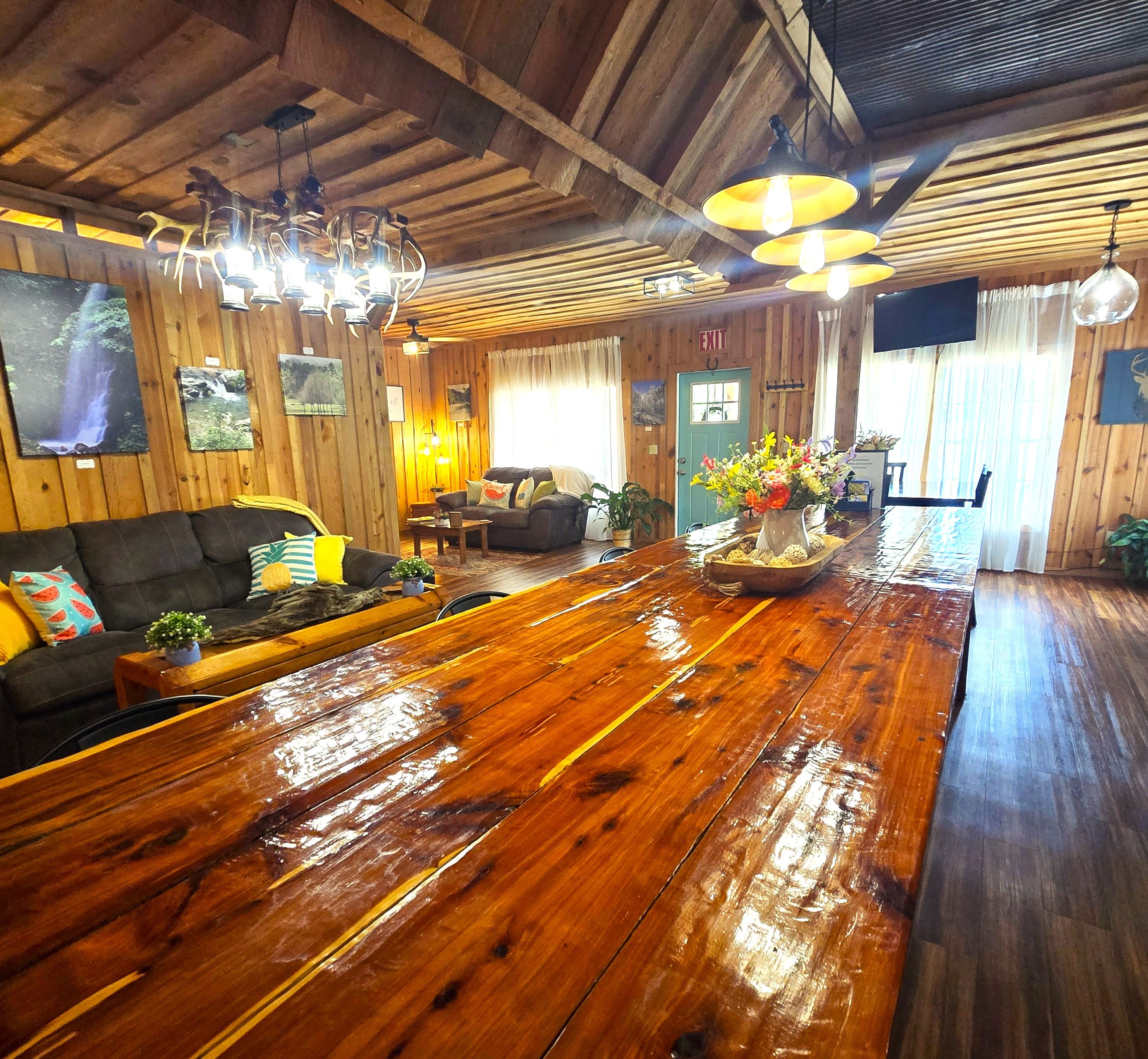 A wooden-floored living room with a sofa, a coffee table, and a dining table.