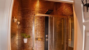 Une salle de bain moderne avec une douche à parois de verre, une porte blanche et un mur à texture.