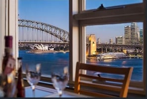 Enjoy a panoramic view of Sydney Harbour Bridge and the Opera House from this room's large window.