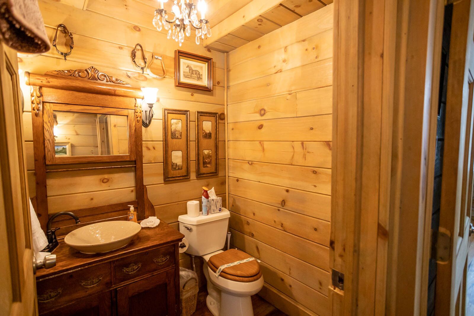 A wooden cabin bathroom with a wooden sink, vanity, and toilet.