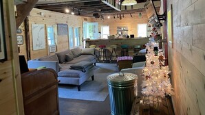 Un intérieur de chalet chaleureux, avec un décor en bois, un coin repas et un sapin de Noël.
