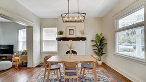 Un coin repas avec une table en bois, des chaises et un tapis à motifs.