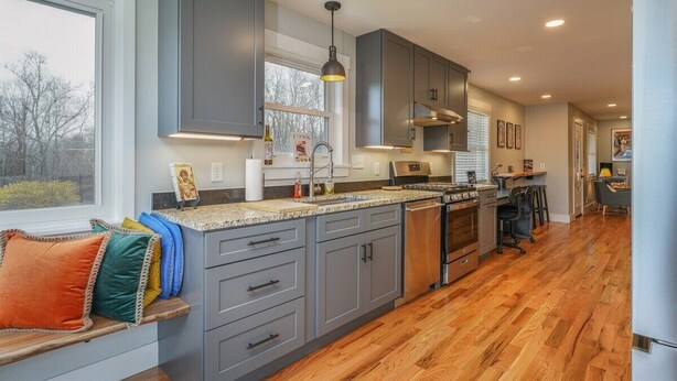 A modern kitchen with grey cabinets, a central island, and a built-in oven. - JB`s Place - One Home with Two Living Spaces! (Brevard)